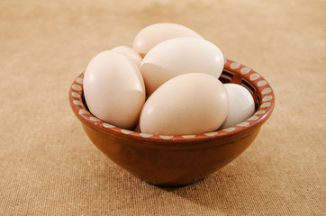 chicken eggs in a plate on the table. Side view.