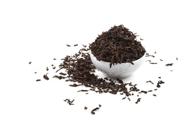 Dried tea leaves in ceramic cup over white background.
