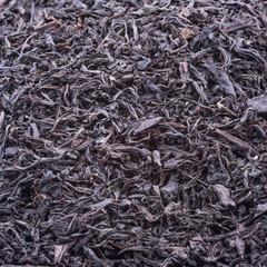 Background of dried tea leaves of dark color. Macro.