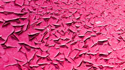 Concrete wall with cracked red paint as abstract background
