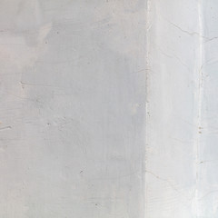White wall with cracked plaster as abstract background