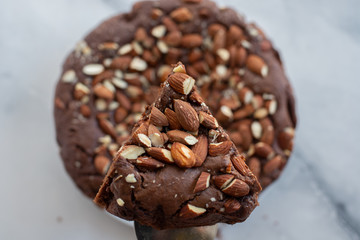 Piece of stack homemade dark chocolate brownies with salted almonds on a table
