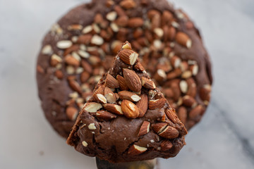 Piece of stack homemade dark chocolate brownies with salted almonds on a table