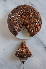 Piece of stack homemade dark chocolate brownies with salted almonds on a table