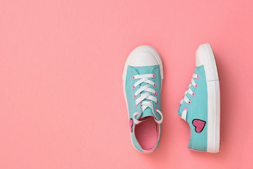 Turquoise with pink sneakers on a coral background. Color trend 2019. Sports style. Flat lay.