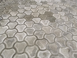 Obraz premium Texture of newly-laid gray curly paving tiles 'Bikini', top view. Abstract pattern of the surface of the paving slabs in the patio, courtyard, garden or square, nobody