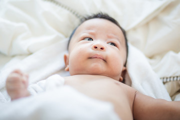 Infant baby boy lying on white blanket