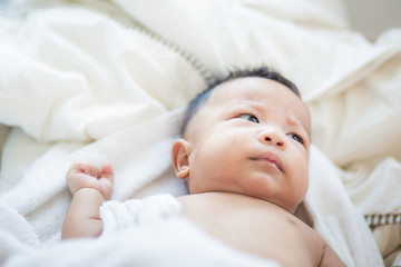 Infant baby boy lying on white blanket