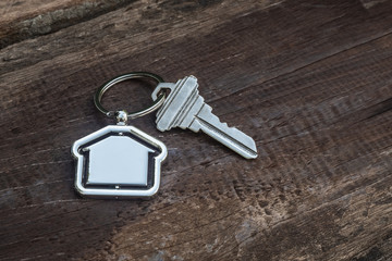 House key with home keyring in on old wood background