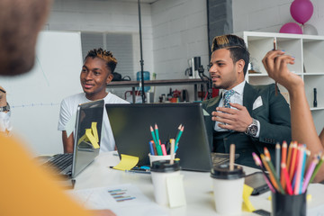 Young international guys attentively listen to the boss during the meeting.
