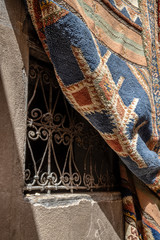 An old rug partially covers a window in Fes, Morocco