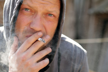 Portrait of the smoking man in a hood.