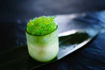 Tobiko caviar topped sushi roll with philadelphia cream cheese on bamboo leave, restaurant serving....