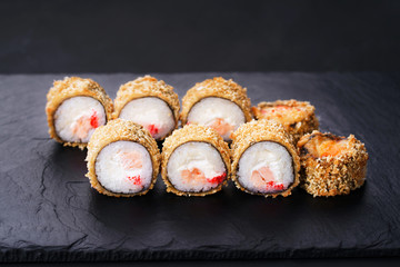 Japanese sushi tempura maki grouper and tobiko roll on slate. Japanese traditional fusion food style, restaurant menu