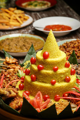 Nasi Tumpeng. Yellow rice in a cone shape. A festive Indonesian rice dish with side dishes.