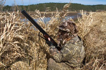 duck hunter sits in a hunting blind of reeds