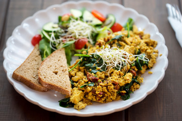 Tofu scrambled eggs with sun dried tomatoes & spinach and tomato & cucumber salad, with bread