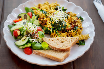 Tofu scrambled eggs with sun dried tomatoes & spinach and tomato & cucumber salad, with bread
