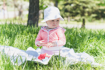 Playing little child with colored toys, outdoors, summer time