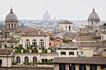 Fototapeta na wymiar Panorama of Rome's rooftops with three church domes. Photograph