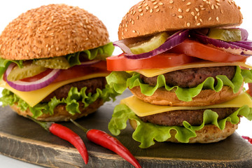 Big fresh tasty burger on wooden board isolated on white background