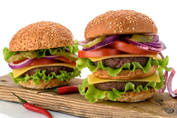 Big fresh tasty burger on wooden board isolated on white background