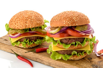 Big fresh tasty burger on wooden board isolated on white background