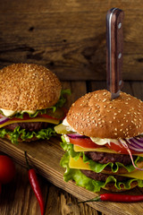 Home cooking burgers on a dark wooden background.