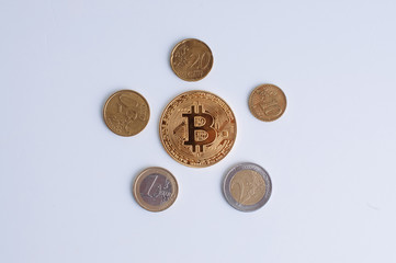 a Bitcoin in the middle of five coins of euro
