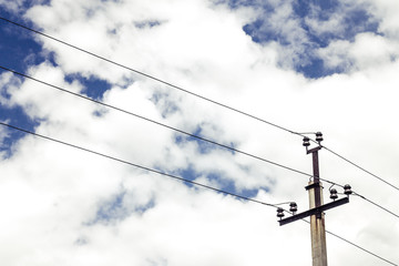 high voltage wires and an electrical pole between them are located under a picturesque sky with...