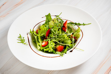 healthy salad with strawberriesa and arugula