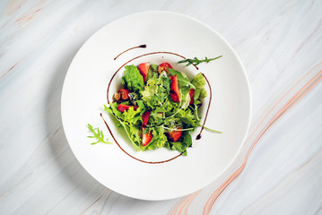 healthy salad with strawberriesa and arugula