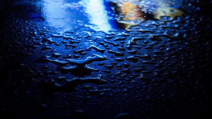Wet asphalt, night scene of an empty street with a little reflection in the water, the night after the rain. Abstract dark neon background with a wet surface, reflection, neon, glare, blurred bokeh.