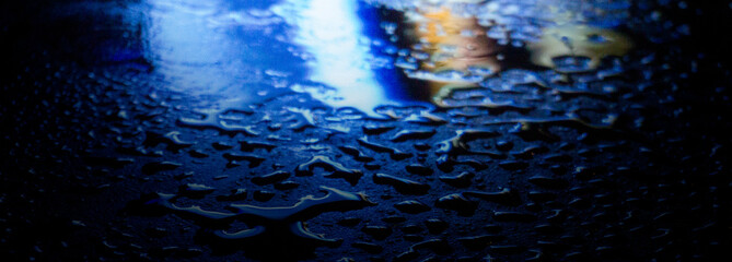 Wet asphalt, night scene of an empty street with a little reflection in the water, the night after the rain. Abstract dark neon background with a wet surface, reflection, neon, glare, blurred bokeh.