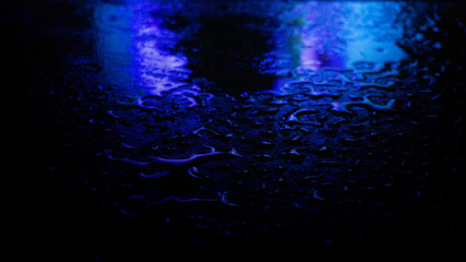 Wet asphalt, night scene of an empty street with a little reflection in the water, the night after the rain. Abstract dark neon background with a wet surface, reflection, neon, glare, blurred bokeh.