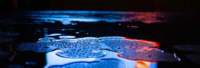 Wet asphalt, night scene of an empty street with a little reflection in the water, the night after...