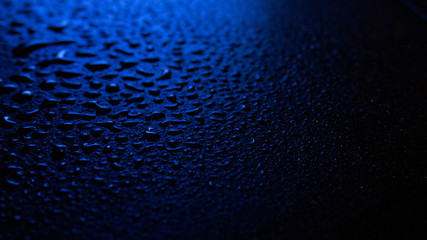 Wet asphalt, night scene of an empty street with a little reflection in the water, the night after the rain. Abstract dark neon background with a wet surface, reflection, neon, glare, blurred bokeh.