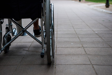 Wheelchair on the outside, in a park on a brick floor