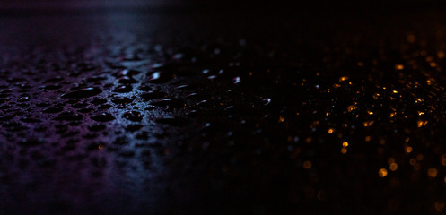 Wet asphalt, night scene of an empty street with a little reflection in the water, the night after the rain. Abstract dark neon background with a wet surface, reflection, neon, glare, blurred bokeh.