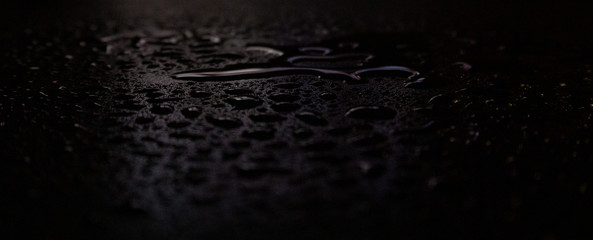 Wet asphalt, night scene of an empty street with a little reflection in the water, the night after the rain. Abstract dark neon background with a wet surface, reflection, neon, glare, blurred bokeh.