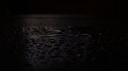 Wet asphalt, night scene of an empty street with a little reflection in the water, the night after the rain. Abstract dark neon background with a wet surface, reflection, neon, glare, blurred bokeh.