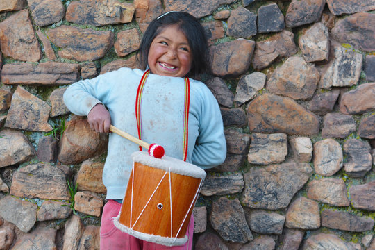Little native american girl playing traditional sikuri drum.