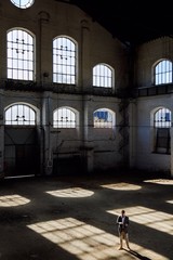 general shot of young business man looking at an electronic tablet in an empty industrial warehouse