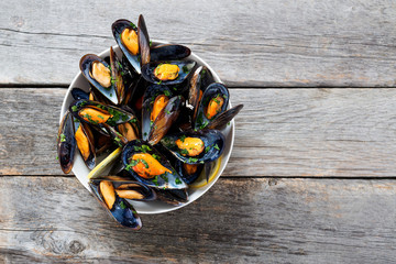 Delicious seafood mussels with  parsley sauce and lemon. - obrazy, fototapety, plakaty