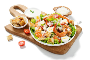 Caesar Salad with Shrimp served with croutons,caesar sauce and parmesan. isolated on white background.