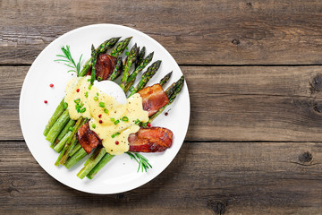 Grilled Asparagus served with poached egg, bacon  and  hollandaise sauce, top view.