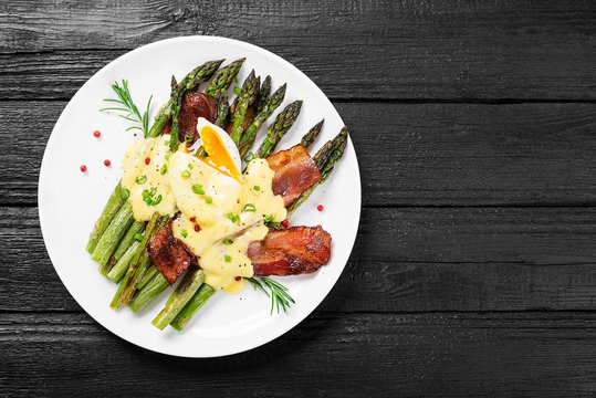 Grilled Asparagus served with poached egg, bacon  and  hollandaise sauce, top view.