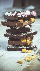 Blocks of rustic chocolate with nuts, coconut, honeycomb and marshmallows. Confectionery.