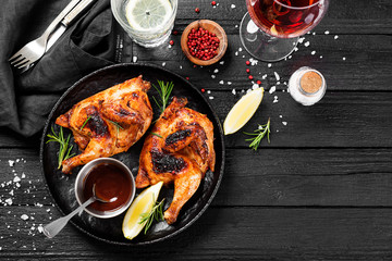 Halves of appetizing grilled juicy chicken with golden brown crust served with lemon...