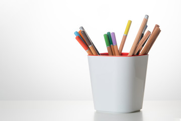 On the table are colored pencils, drawing sheets with graphics.